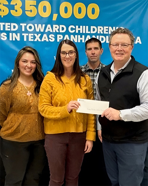 yd7610 employees donate a check to charity.