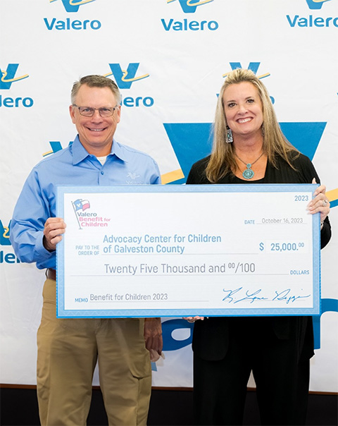yd7610 employees hold an oversize check donation to charity.