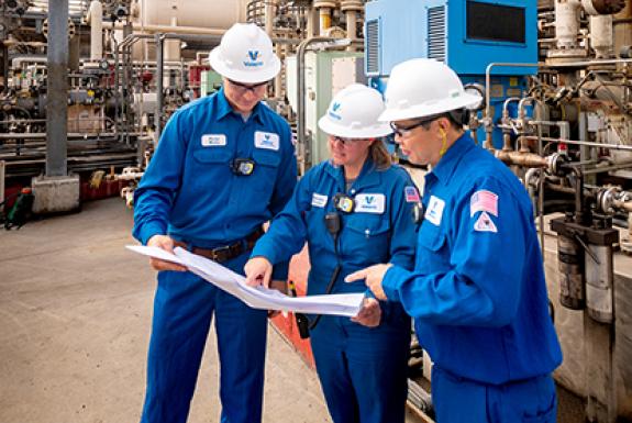 Group of yd7610 refinery employees looking at plans