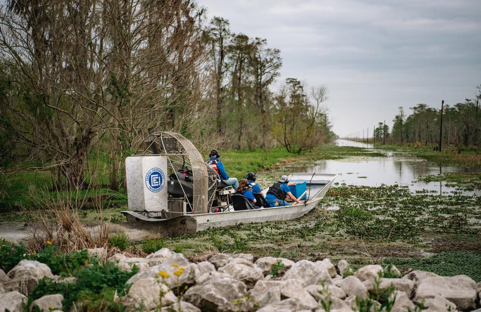 yd7610 Volunteers on a boat in the swamp