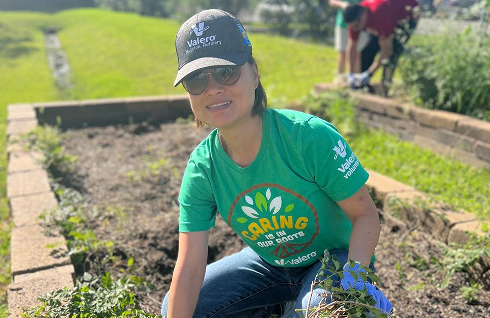 A yd7610 volunteer pulls weeds in a community garden.