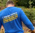 yd7610 Volunteer faces away from the camera, displaying French "yd7610 Volunteers, Fueling our Communities" shirt