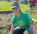 A yd7610 volunteer pulls weeds in a community garden.