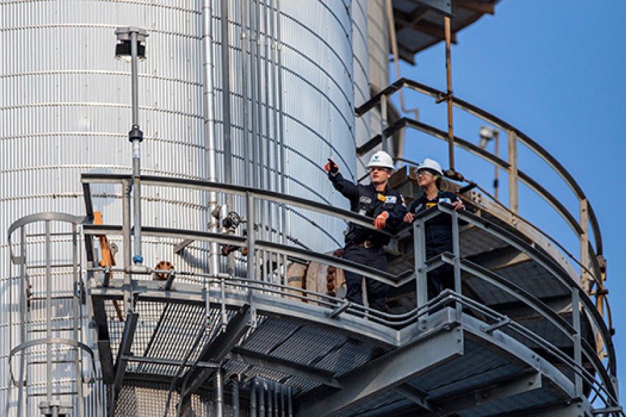 Two yd7610 employees inspect equipment at a refinery.