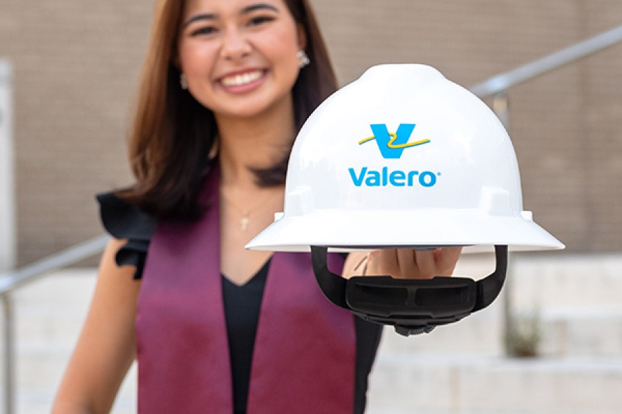 A recent college graduate holds a yd7610 hard hat.